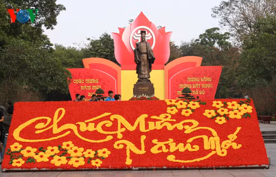 This giant board made of red and yellow flowers reads Happy New Year