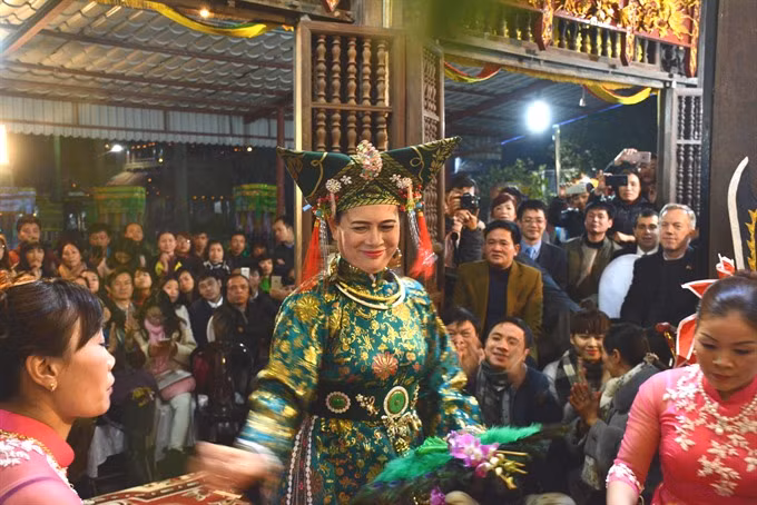 Spiritual ceremony: Foreign diplomats and local inhabitants watch a hầu đồng performance at the Phủ Dầy Relic Complex in Nam Định province. The Beliefs in the Mother Goddesses of Three Realms, originating in Việt Nam, has been practised in numerous northern mountainous provinces across the nation since the 16th century. —VNS Photo Minh Nhã Read more at http://vietnamnews.vn/life-style/349478/viet-nam-develops-positive-role-in-unesco.html#fytIQcs2bdz6wGpc.99