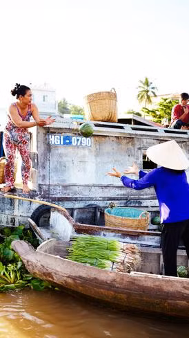 The relatively peaceful floating market of Cai Rang at early dawn. Traders carry watermelons, pineapples and beets to small boats.