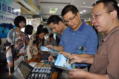 Tourists view the promotional leaflets of Halong Bay.