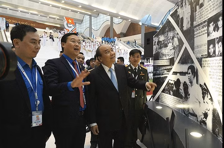 Prime Minister Nguyen Xuan Phuc (second from right) visits a photo exhibition covering the history of the establishment and development of the Ho Chi Minh Communist Youth Union as part of activities celebrating the 11th National Congress of the youth union.