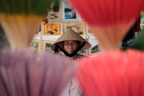 A woman peers through an incense display at her shop in Hue.