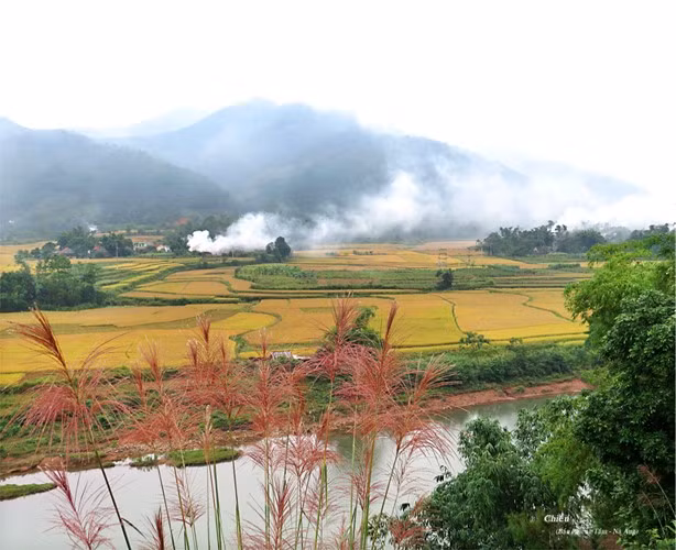 Smoke rises from the village in late afternoon