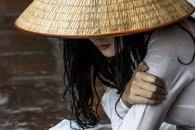 Vietnamese girl wearing Non la (conical hat) and Ao Dai (traditional dress) by Erol Doganer