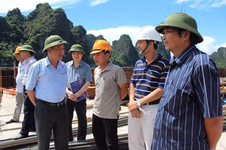The Vice Chairman Do Thong (L) supervises the project