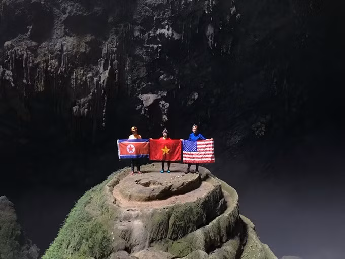 Flying the flag: Visitors at Én Cave in Quảng Bình Province with flags of the DPRK, USA and Việt Nam. The DPRK-USA Summit, with the participation of nearly 3,000 international reporters, is a great opportunity for Vietnamese tourism promotion. — VNA Photo
