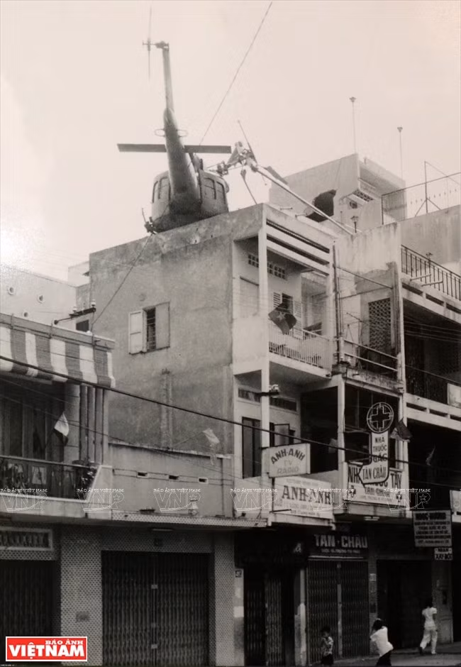 A shot-down helicopter on top of a house in Sai Gon