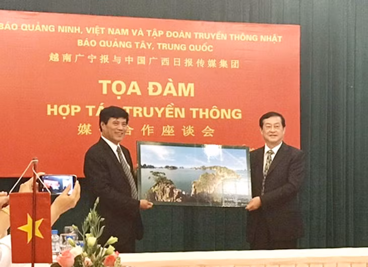 Quang Ninh Newspaper's Chief-Editor Nguyen Tien Manh present a picture of Halong Bay to the Guangxi Daily Newspaper Media Group's Chairman of the Board-Chief Editor Ye Leyang.