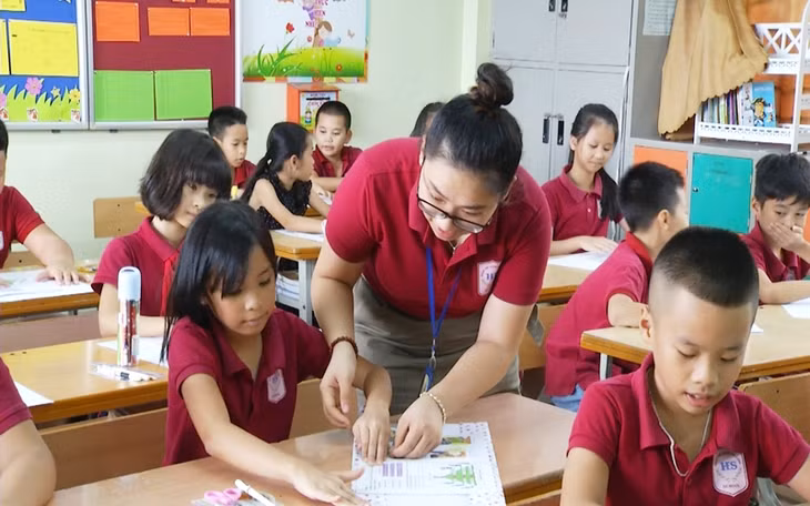 A teacher at Doan Thi Diem Elementary School instructs her pupils to use wrapping papers for books and textbooks