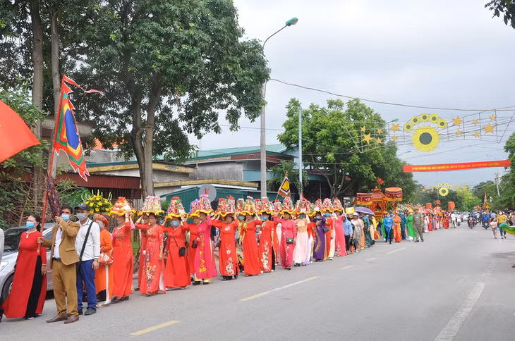A large procession stretches across the streets of Quang Yen town.