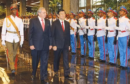 Cuban President Raul Castro and his Vietnamese counterpart Truong Tan Sang (right) review an honour guard at the Revolution Palace in La Havana on Tuesday.—VNA/VNS Photo Nguyen Khang