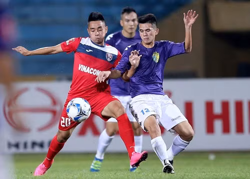 Quang Ninh’s Xuan Hung (left) fights for the ball against Ha Noi T&T in the National Football Cup, second leg final in Ha Noi yesterday. Quang Ninh won 2-1, and lifted the cup with an aggregated 6-5 win after two legs(the two team drew 4-4 in the first leg. Photo Vnexpress