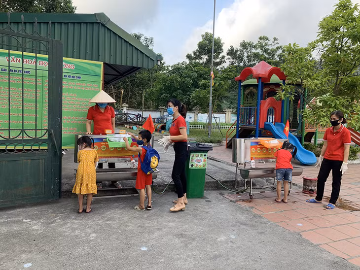 Teachers instruct their students how to wash their hands properly at Dai Yen Primary School and Vu Oai Kindergarten