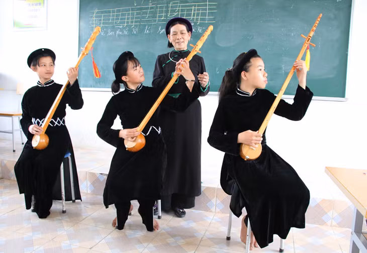 Hoang Thi Vien (the third from the left), a Then artisan, is teaching her students about Then singning and gourd lute (dan tinh). Photo by Nguyen Dung/baoquangninh.com.vn