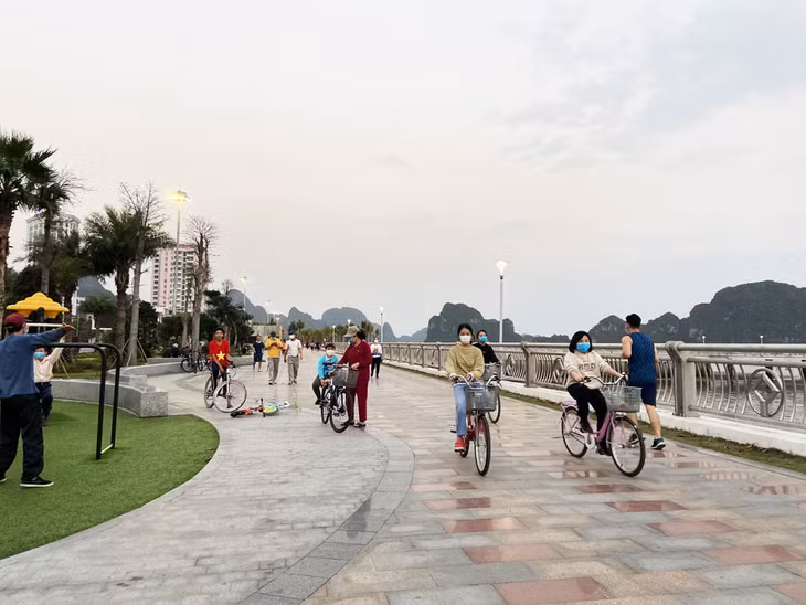 Locals and visitors wear face masks when going sightseeing at the coastal road of Tran Quoc Nghien in Ha Long city.