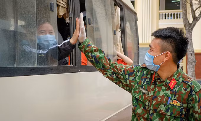 A soldier bids farewell to people who arrived from overseas and were quarantined at his military barracks in Hanoi, March 11, 2020. Photo by VnExpress/Giang Huy.