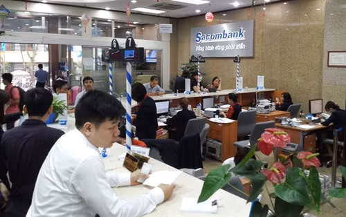 Customers deposit money at Sacombank’s branch in Hà Nội. Sacombank offers the highest deposit rate of 7.55 per cent for 13-month deposit of at least US$22 million. — VNS Photo Đoàn Tùng Viet Nam News