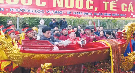 Representatives move fish caught in an ancient pond to a boat to offer them to the Tran Kings at the Tran Temple Festival, one of the biggest in Viet Nam. — VNA/VNS Photo Van Dat