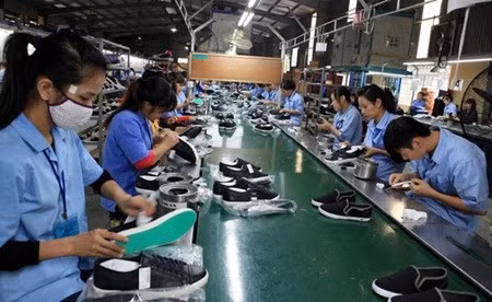 Workers at Dong An Economic Investment and Development Company in Hanoi make shoes for export