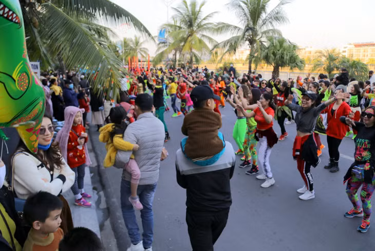Tourists and dancers together join the street festival.