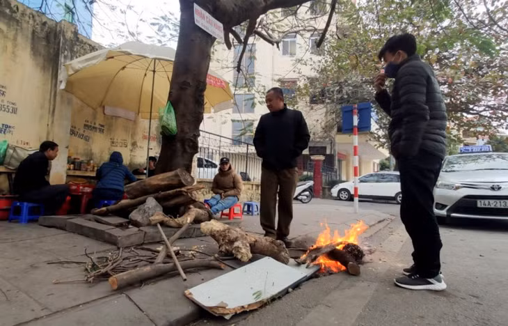 Outdoor laborers such as sellers, taxi drivers and motorcycle taxi drivers burns firewood to warm himself in the cold winter.