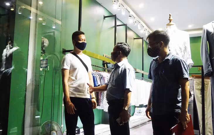 An official in Bach Dang Ward (Ha Long City) asks a businessman to follow the disease prevention and control rule when reopening
