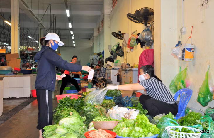 Traders and locals wear face masks and maintain distance