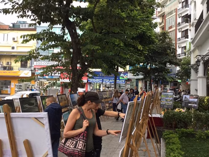 Street art: Visitors enjoy photos at the exhibition. — VNS Photo Minh Thu