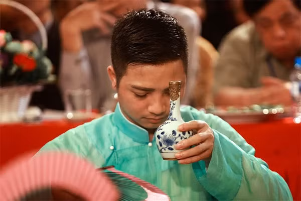 Devoted: An assistant to a medium offers wine during the hau dong ritual.