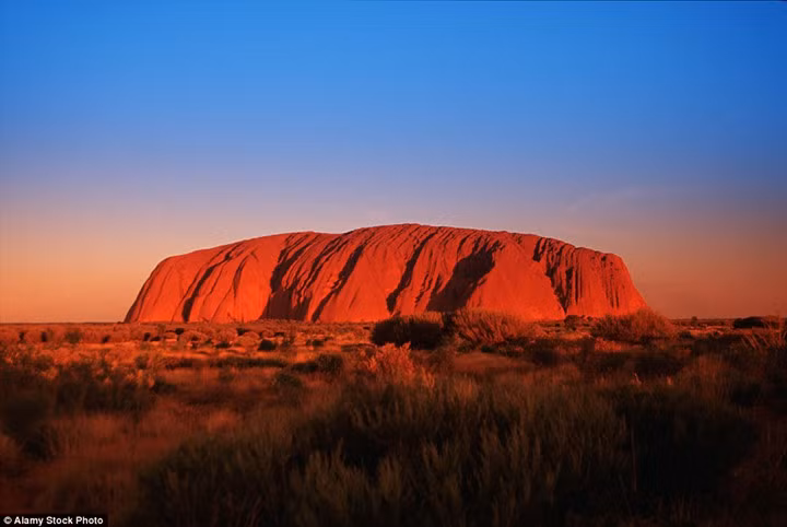 It's hard to look at this - the blood-red hue of Ayers Rock at sunset - without feeling your eyes heat up. Lumped in the centre of a flat and desolate area of the Australian outback