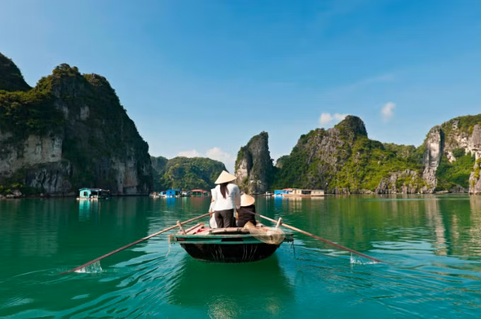 A woman sails a boat in Ha Long Bay. Photo by VnExpress