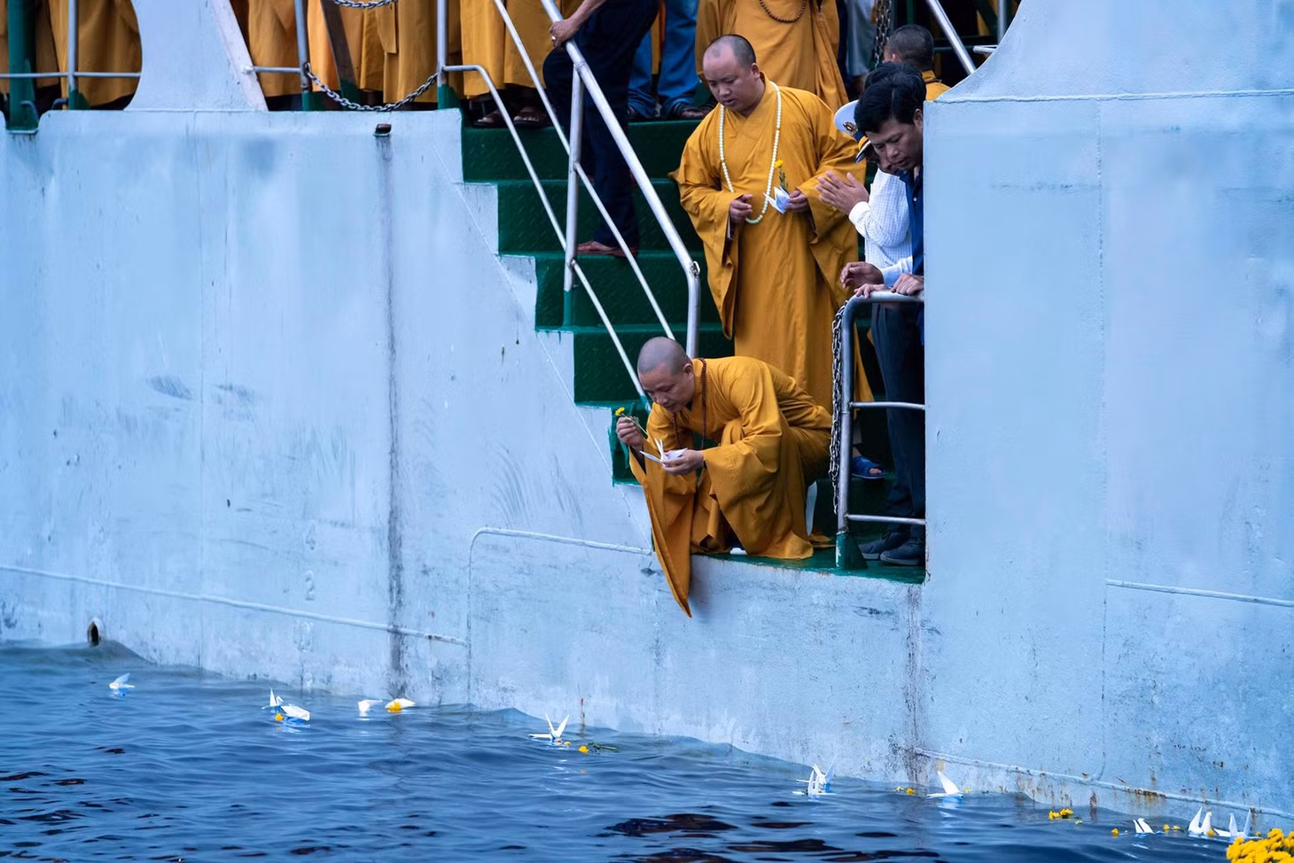 Buddhist monks release flowers and paper cranes into the sea to commemorate the fallen soldiers.