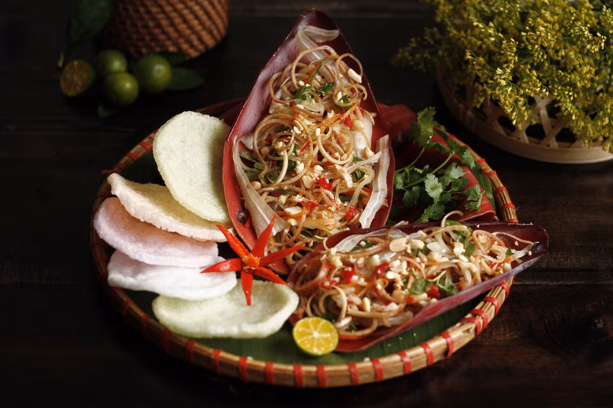 Banana flower salad showcases the vibrant colors of thinly sliced banana flowers and fresh herbs. Photo by VnExpress/Bui Thuy