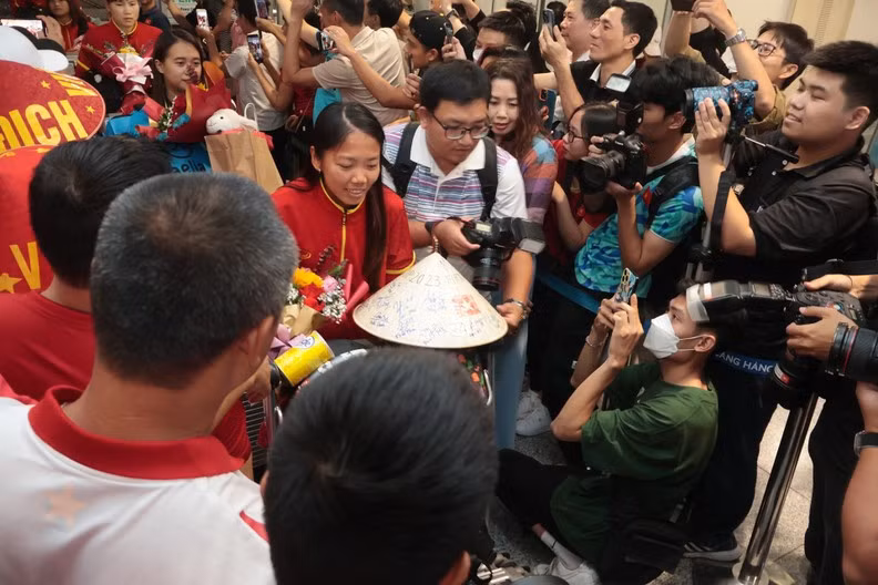 Huynh Nhu and her teammates surrounded by the press and fans.
