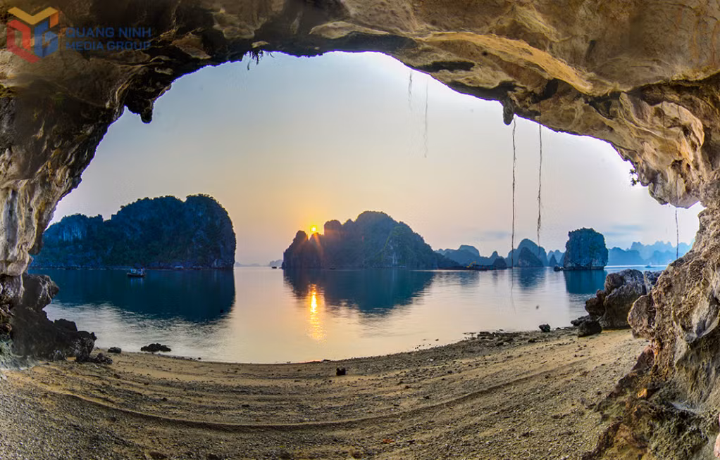 Seen through a natural rock crevice in the Vung Ha area, towering limestone mountains rise imposingly, creating a sense of peace and stillness.