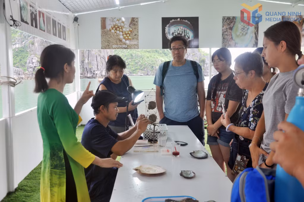 International tourists watch the crafting of cultured pearls in the Vung Vieng area of Ha Long Bay.
