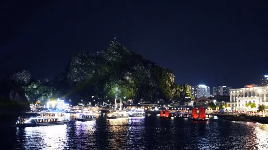 Cruise ships and tourist boats gather at the foot of Bai Tho Mountain.