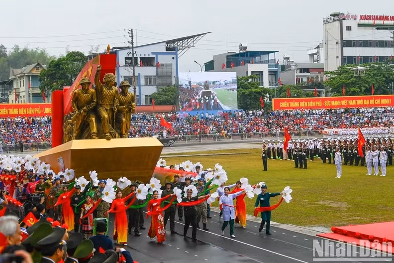 A float carrying sculptures of soldiers dragging artillery with the text “Determined to fight, determined to win”.
