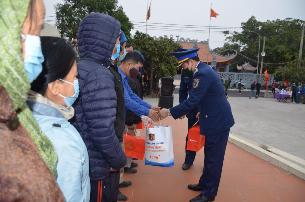 Colonel Tran Van Xuan, Deputy Political Commissar of the Vietnam Coast Guard, presents gifts to families under preferential treatment policies and the poor in Quan Lan island commune.