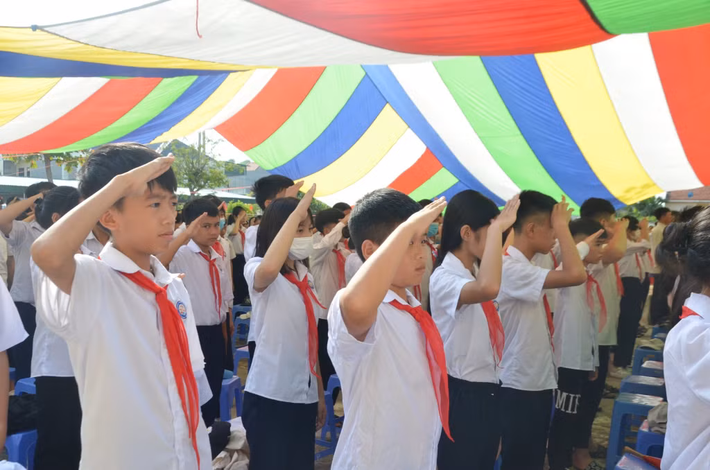 Các bạn nhỏ cấp tiểu học nghiêm túc thực hiện nghi lễ chào cờ.
