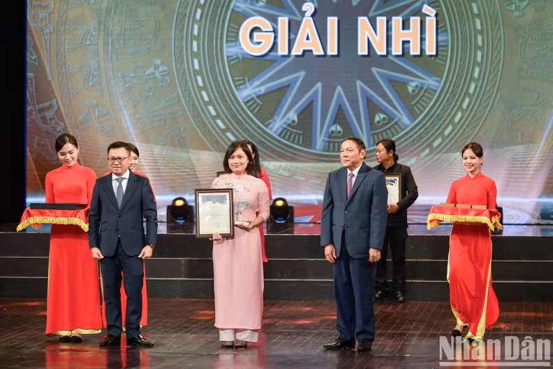 Nhan Dan Editor-in-chief Le Quoc Minh and Minister of Culture, Sports and Tourism Nguyen Van Hung present the second prizes.