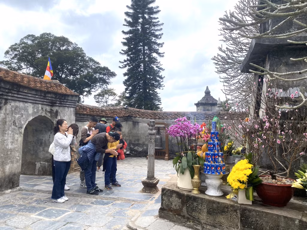 Locals and tourists offer incense at Hoa Yen pagoda.