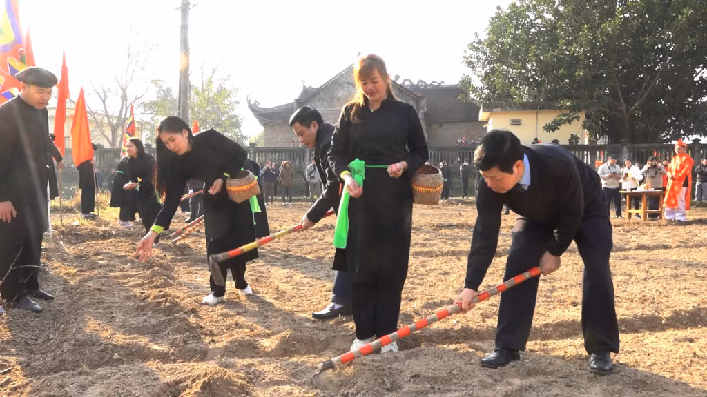 Các đại biểu và nhân dân thực hiện nghi lễ cuốc hố tra hạt cầu mong mưa thuận gió hòa, mùa mùa bội thu.