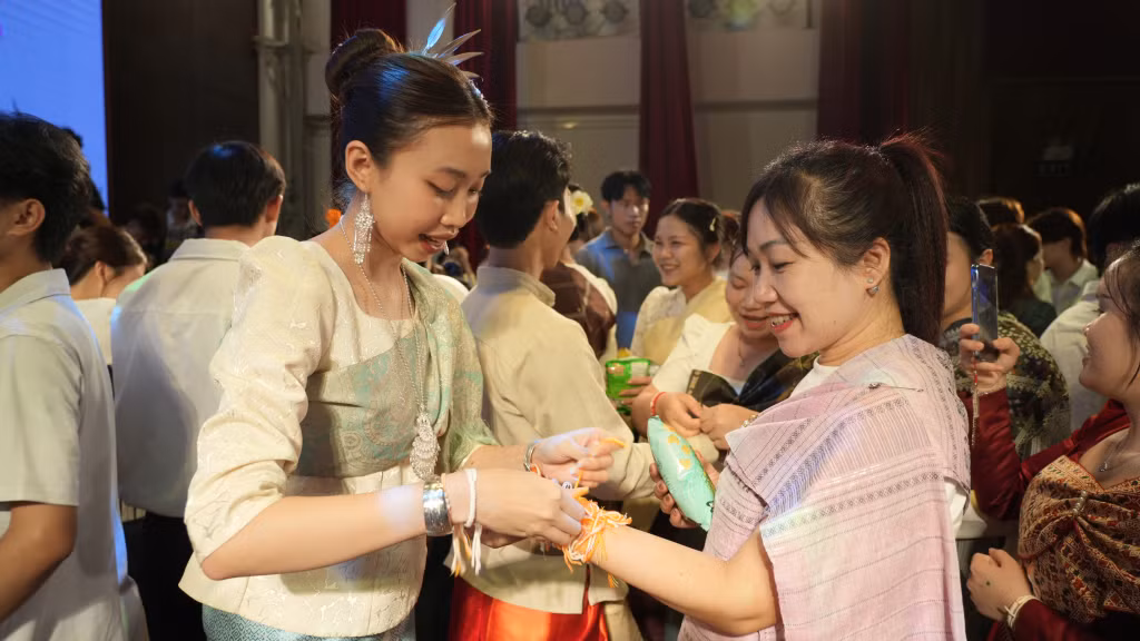 A wrist-tying ceremony is performed to wish for luck and well-being in the New Year.