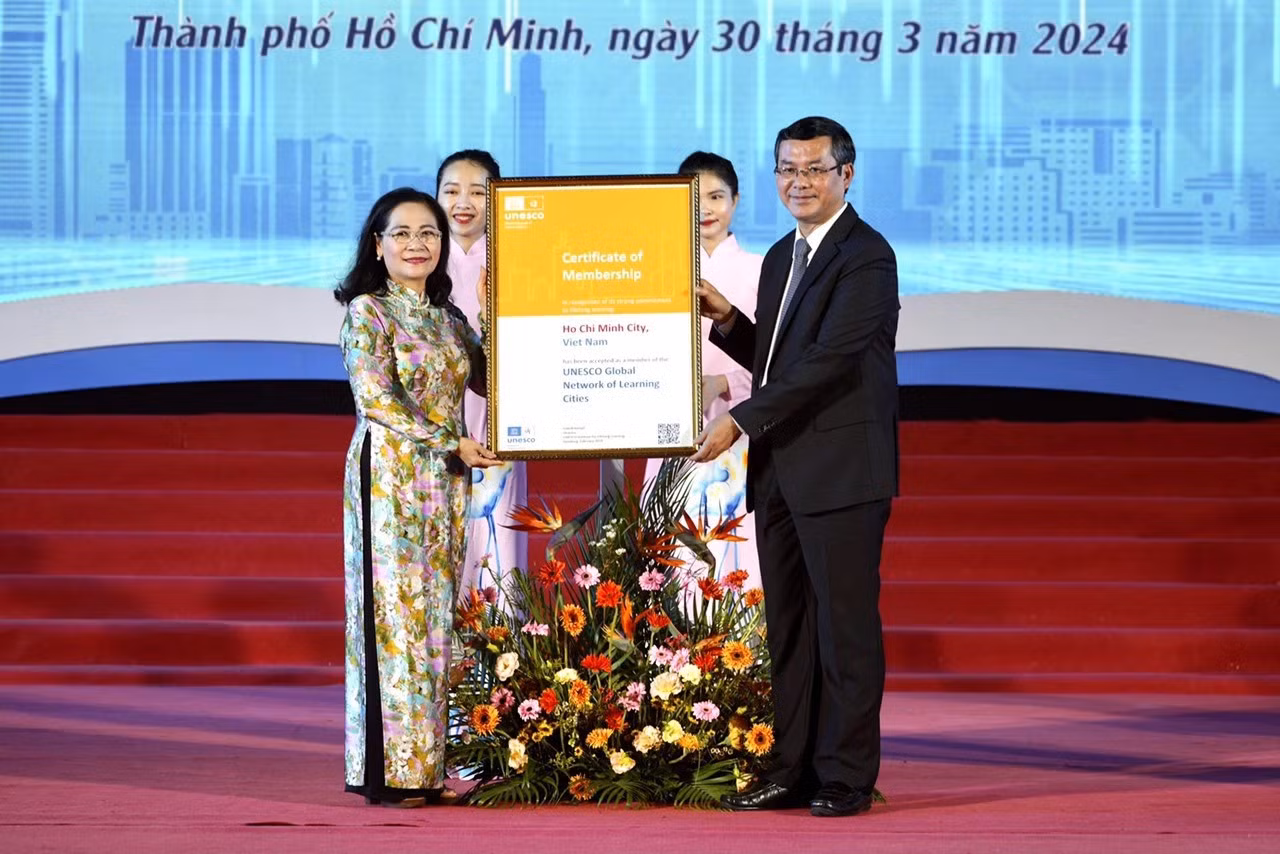 Nguyen Van Phuc (R), Deputy Minister of Education and Training, and Nguyen Thi Le, deputy secretary of the Ho Chi Minh City Party Committee, proudly display the certificate recognizing the city as a global learning city. Photo: Huu Hanh / Tuoi Tre.