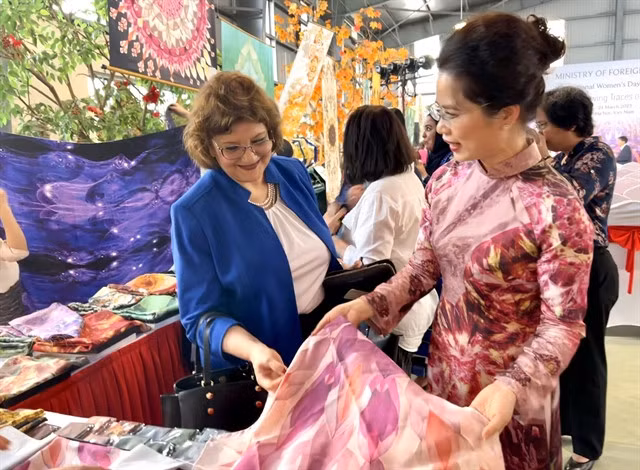 Founder of De Silk, Văn Hằng, presents a product to a guest at the event.