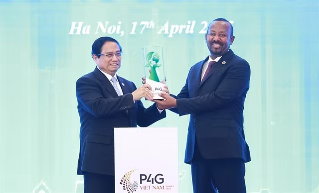 Vietnamese Prime Minister Phạm Minh Chính hands over a symbolic statue to his Ethiopian counterpart Abiy Ahmed Ali, passing the responsibility of hosting the next forum, at the closing ceremony of the fourth edition of P4G in Hà Nội on Thursday. — VNA/VNS Photo Dương Giang