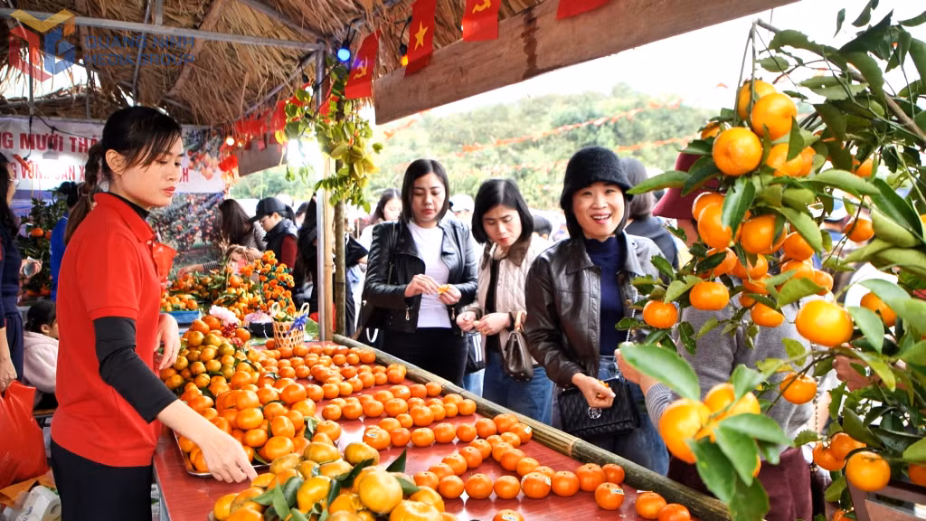 Visitors purchase oranges at a “Rural Market” booth during Van Don Orange Festival