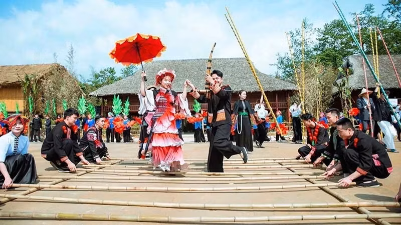 Tourists join a bamboo pole dance in Sa Pa Town, Lao Cai Province. (Photo: THANH TAM)