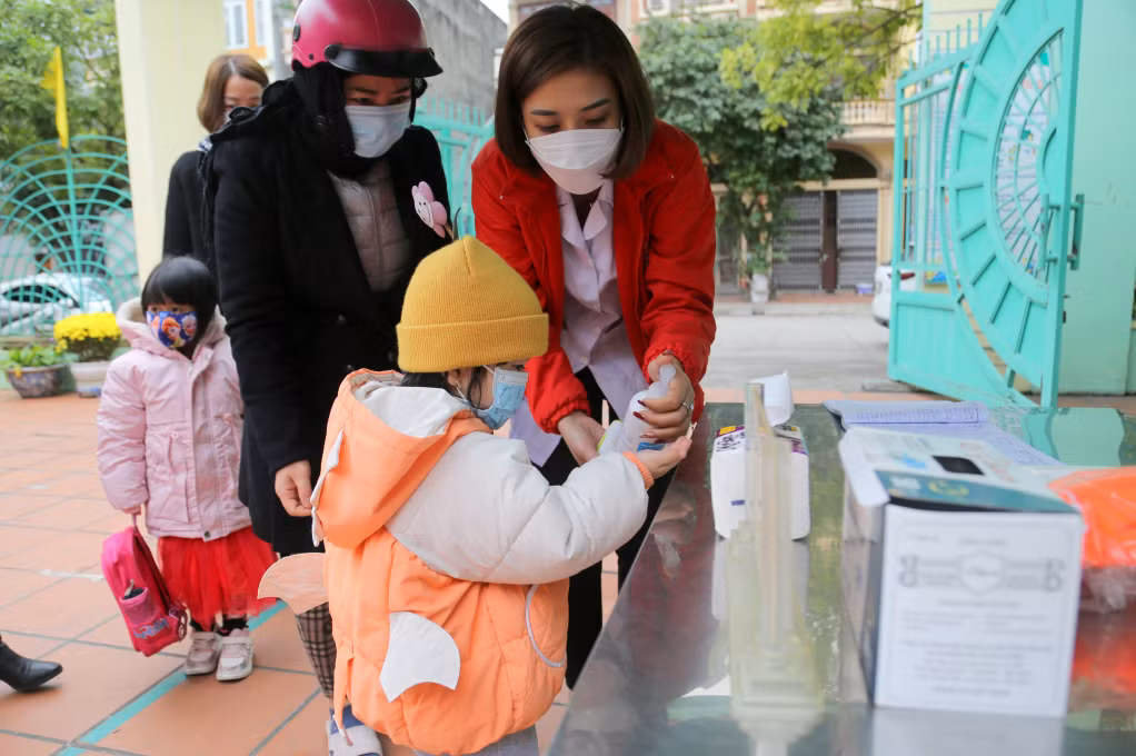 Preschool pupils are carefully guided how to clean their hands.